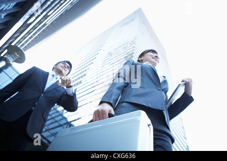 Eine Nahaufnahme von einer Business-Frau und ein Business-Mann zwischen Bürogebäuden Stockfoto