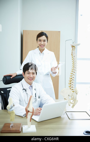 Eine weibliche Chirurgen stehen neben einem männlichen Chirurgen Stockfoto