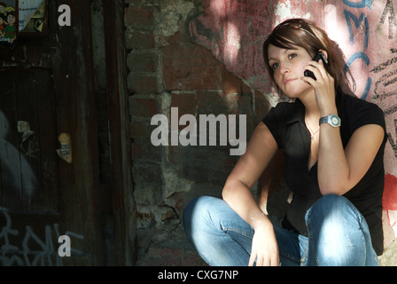 Berlin, rief lehnt gegen eine Wand-Frau ihr Handy Stockfoto