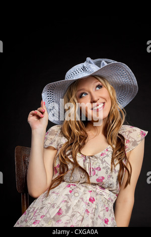 Blonde schwangere Frau Porträt im Strohhut Stockfoto