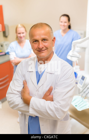 Porträt von Reifen Zahnarzt Mann mit Team in Zahnmedizin Klinik Stockfoto