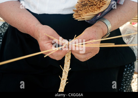 Frau, die Strohhüte auf dem Bauernmarkt. Rom, Italien Stockfoto