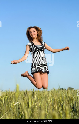 Fröhliches attraktive Mädchen im Feld springen Stockfoto