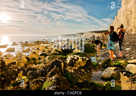 Ein Junge und zwei Frauen genießen Sie Birling Gap Strand bei Sonnenuntergang Anfang September. East Sussex, England, UK Stockfoto