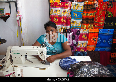 Frau aus dem Dorf Waikkal Sri Lanka arbeiten bei einer Nähmaschine machen Saris und andere Kleidung Stockfoto