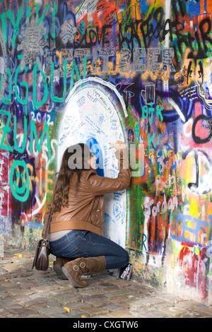 Junger Fan schreiben eine Botschaft der Liebe auf der John-Lennon-Mauer in Prag Tschechische Republik Stockfoto