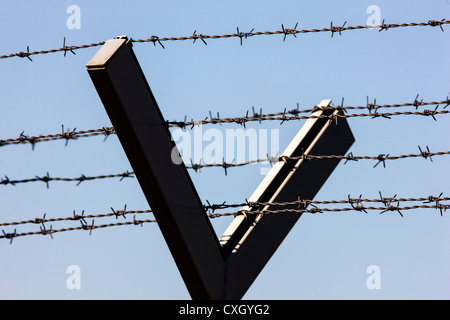 Stacheldraht, eine Fläche zu schützen. Eisen, Metall Zaun mit Stacheldraht obendrauf. Stockfoto