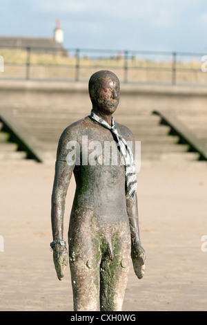 ein Bügeleisen Mann, Teil von Antony Gormleys Skulptur "Woanders", gekleidet in einem Unentschieden, Crosby Strand, Liverpool, Merseyside UK Stockfoto