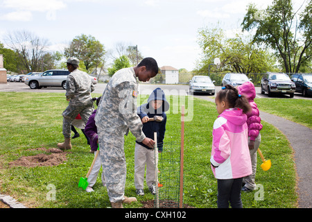 ROTC Hilfe für Kinder in einer Grundschule Pflanze Bäume am Tag des Baumes Stockfoto