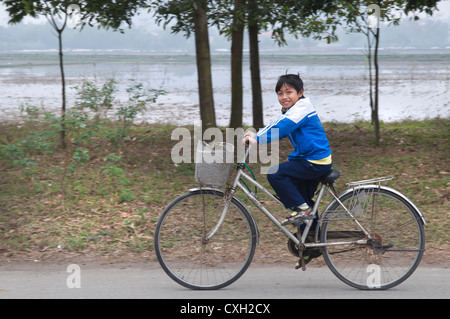 Lächelnd vietnamesische Schule junge Haus reiten. Schuss in der Nähe von Tam Coc, Ninh Binh, im Norden von Vietnam. Stockfoto