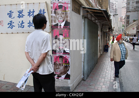 Ein lokaler Chef Studien Plakate der drei Kandidaten für die Hong Kong 2012 Chief Executive Wahlen in Wan Chai Stockfoto