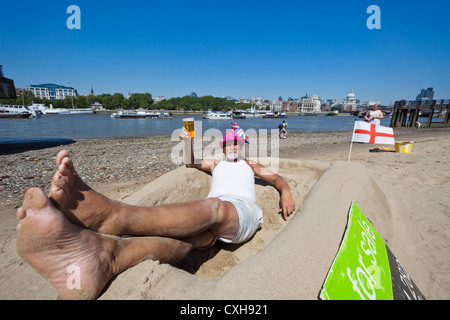 England, London, Bankside, Sandskulpturen-Künstler, die am Ufer der Themse entspannend Stockfoto