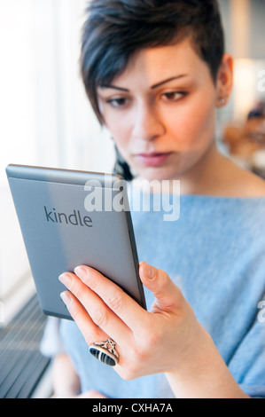 Junge Frau lesen Ebook auf eine Amazon Kindle, England, UK Stockfoto