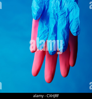 Leere rosa und blauen Haushalt Schutzhandschuhe zum Trocknen auf blauem Hintergrund aufgehängt Stockfoto