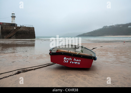 Kleines Fischerboot bei Ebbe in der Morgendämmerung im kornischen Fischerhafen von St. Ives. Stockfoto