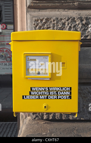 Ein helles Gelb österreichischen Briefkasten fest an einer Wand in Wien, Österreich. Stockfoto