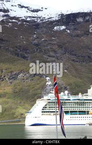 Schöne Geiranger in den norwegischen Fjorden mit Kreuzfahrtschiff im Hintergrund. Stockfoto