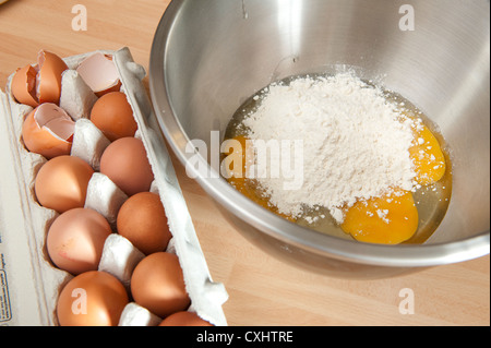 Eiern und Mehl vermischt in einer Metallschale in einer Küche. Stockfoto