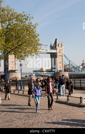 Touristen genießen Sie einen Spaziergang an der Themse mit Tower Bridge im Hintergrund, London, England. Stockfoto