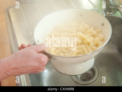 Dampf steigt von Nudeln in einem Sieb über einer Küchenspüle abgelassen. Stockfoto