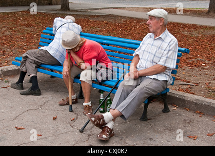 Ältere Menschen sitzen auf der Parkbank mit leeren Bierflaschen in Sewastopol. Stockfoto