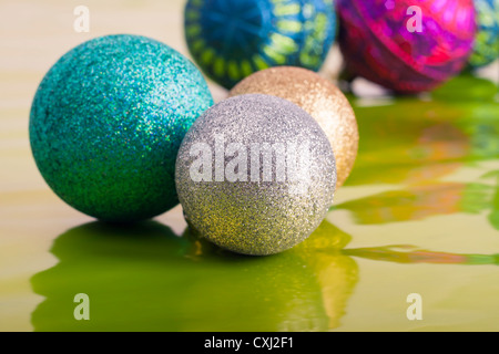 Bunte Weihnachtskugeln auf glänzend grünen Hintergrund. Stockfoto