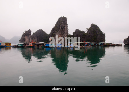 Schwimmende Dorf und Kalkstein Karst Felsformationen, Halong Bucht, Vietnam Stockfoto