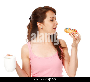 Fit junge Frau, die einen Krapfen und Kaffee (auf weißem Hintergrund) Stockfoto