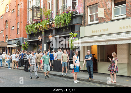 Menschen stehen vor der Comptons Bar in Soho, London, UK Stockfoto