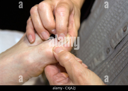 Reflexologin am Arbeitsplatz bei einer Veranstaltung von alternativen Therapien, Alton, Hampshire, UK. Stockfoto