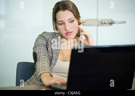 Junge Büroangestellte in Stuhl suchen zurück gelehnt satt. Stockfoto