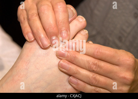 Reflexologin am Arbeitsplatz bei einer Veranstaltung von alternativen Therapien, Alton, Hampshire, UK. Stockfoto