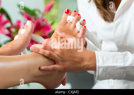 Frau empfangende Pediküre in einem Day Spa, Füße Nägel poliert bekommen und sie ist immer eine Fußmassage Stockfoto