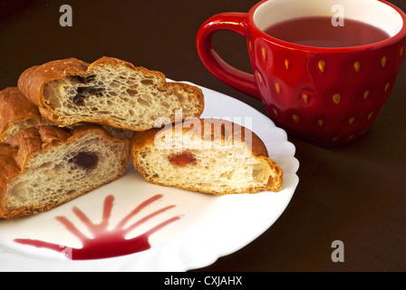 Eine Tasse Früchtetee mit frischen Croissants golden Stockfoto