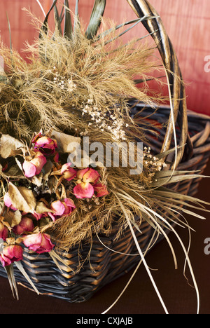 Anordnung von getrockneten Rosen in einem Korb Flechten Stockfoto