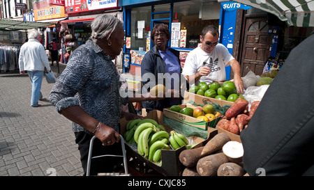 Frauen für Obst und Gemüse auf einem Markt einkaufen stall in Walthamstow High Street, East London England UK Stockfoto