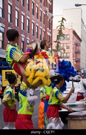Chinesische Tänzerinnen ein Löwentanz in einer Straße von Chinatown - New York City, USA Stockfoto