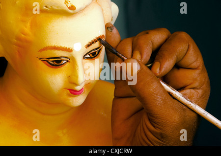 Die Malerei arbeitet am Gesicht des tönernen Idols des Hindu-Gottes in Kumortuli, Westbengalen, Indien. Stockfoto