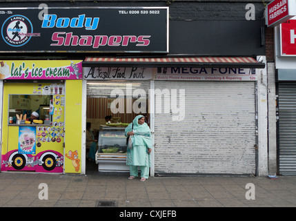 Body Shaper Fitnessstudio über Ice Cream Shop und Al Fazal Food Point Shop Walthamstow HIgh Street London England KATHY DEWITT Stockfoto