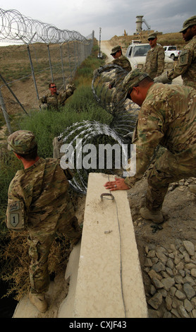 US-Flieger Aufmachungen Stacheldraht entlang des Umfangs der Bagram Airfield Afghanistan 26. September 2012 um base Verteidigung gegen Aufständische Bedrohungen zu erhöhen. Stockfoto