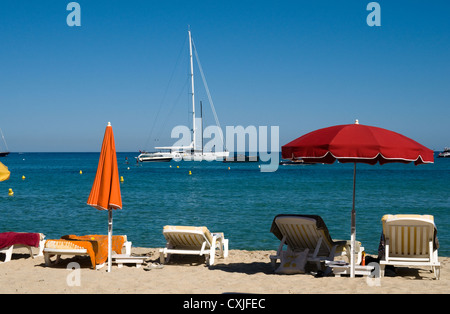 Sonne in der Nähe von liegen und Sonnenschirmen am goldenen Strand von Pampelonne Strand St. Tropez im Süden von Frankreich Stockfoto