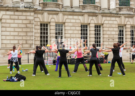 Szene außerhalb der Stadt Halle mit einer Gruppe von jungen Frauen tanzen die Zumba passen auf Rasen in Belfast County Antrim Nordirland UK zu halten Stockfoto