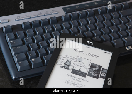 Eine Kobo Touch Ereader (Ebook) wird fotografiert sitzt oben auf einer Computer-Tastatur angezeigt. Stockfoto