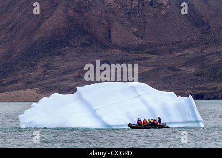 Schlauchboot mit Touristen Küsten von kleinen Eisberg in Nunavut, Kanada. Sommer, hohe Arktis. Stockfoto