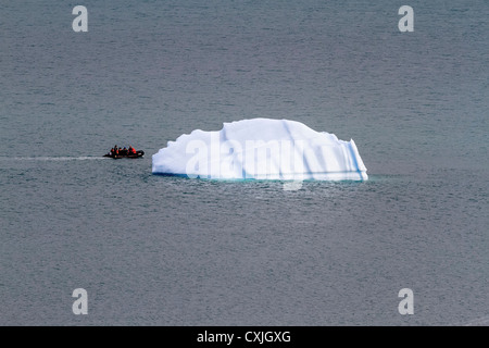 Schlauchboot mit Touristen Küsten von kleinen Eisberg in Nunavut, Kanada. Sommer, hohe Arktis. Stockfoto