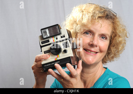 Weibliche Frau mit einer alten Polaroid Land Kamera 1000 UK Stockfoto