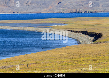 Die Menschen gehen durch die Tundra der Mitdlorfik, einer unbewohnten Bucht entlang der Westküste Grönlands. Stockfoto