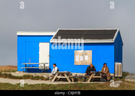 Zwei Frauen und ein Mann sitzen Ouside ein bunt bemalten Haus Itilleq, ein Dorf von 85 Inuit-Menschen in Grönland Stockfoto