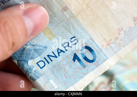 Hand hält eine tunesische zehn Dinar-Note Stockfoto