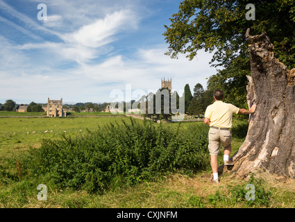 Mann sucht in der St. James Church gesehen über Wiese in alten Cotswold Stadt von Chipping Campden Stockfoto